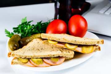 Lunch at a workplace - sandwiches near the laptop