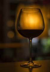glass of red wine in dark cozy bar interior