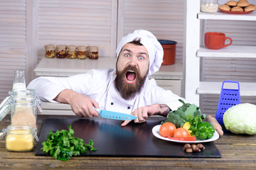 Chef man. Kitchen accessories, cooking equipment. Male chef cutting his finger. Bearded man cut in...