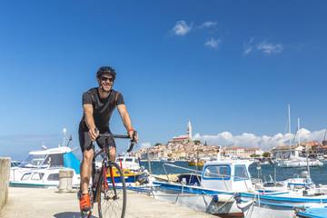 Kroatien, Istrien, Rovinj, Rennradfahrer geniesst Tour am Hafen