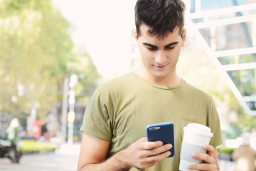 Young man typing message with mobile phone