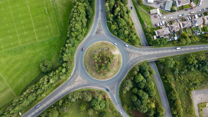 Top down aerial view of a traffic roundabout on a main road in an urban area of the UK - obrazy, fototapety, plakaty