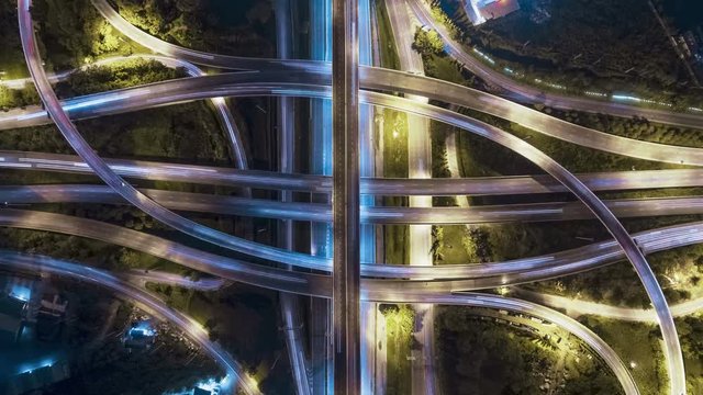 Hyperlapse timelapse of night city traffic on 4-way stop street intersection circle roundabout in bangkok, thailand. 4K UHD horizontal aerial view.
