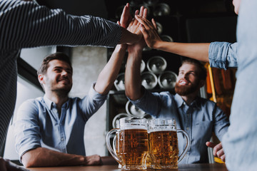 Company Friends Sitting and Drinking Beer in Pub