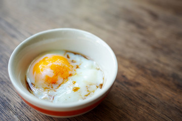 Onsen tamago egg or soft-boiled egg in traditional Japanese served with paper and shoyu soy sauce, copy space