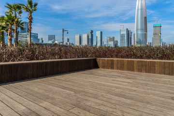 Empty wooden footpath front of the city skyline
