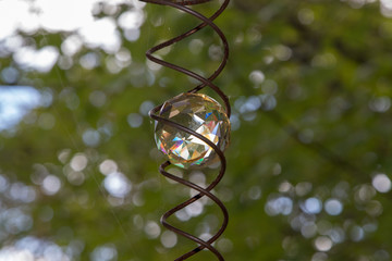 Glass sun catcher decoration with leafy background, summer, no peopl.