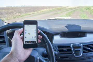 Car with phone navigator on a country road in summer