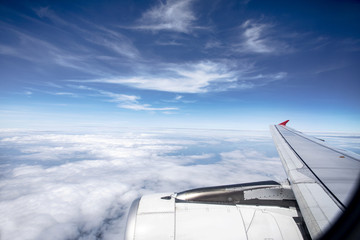 through plane window with beautiful white cloud and blue sky