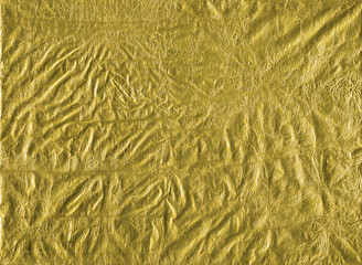 Shiny yellow gold crumpled wrapping paper foil texture for wallpaper decoration element background, stock photo image