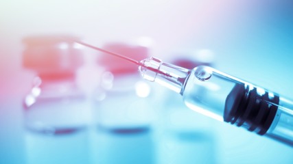 Vaccine vial dose flu shot drug needle syringe,medical concept vaccination hypodermic injection treatment disease care hospital prevention immunization illness disease  baby child.blue background 