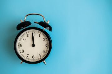 Festive holiday New Year and Christmas blue background with alarm clock. Flat lay. Top view.