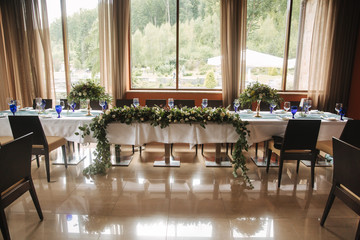 Decorated table for wedding celebration. Bright restaurand with a lot of windows