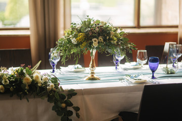 Decorated table for wedding celebration. Bright restaurand with a lot of windows