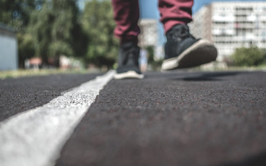 A Teenager Jogging Along The White Line At The Running Track Of The School Outdoor Training Ground On A Summer Day. Copy Space.