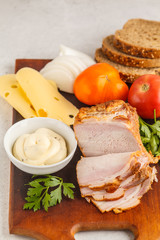 Ingredients for ham and cheese sandwiches on a wooden board, white background.