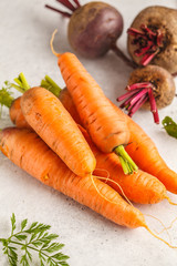 Raw carrots and beets on a white background.