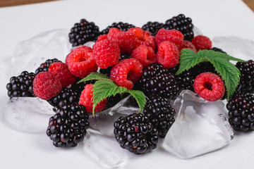 Large blackberries. Blackberries in a white plate on a wooden table.
