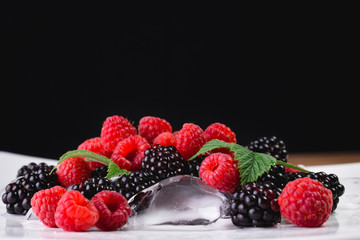 Large blackberries. Blackberries in a white plate on a wooden table.