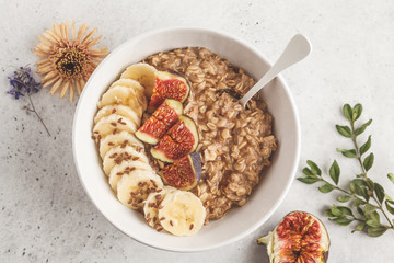 Autumn oatmeal with banana, fig and flax seed. White background, top view