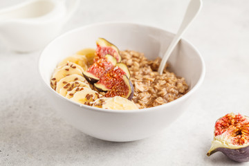 Oatmeal with banana, fig and flax seed. White background