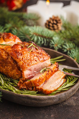 Baked Christmas pork (ham) with rosemary on Christmas table