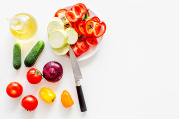 Vegetarian food concept. Set of vegetables for stew. Squash, bell pepper, tomato, spices, oil on white background top view copy space
