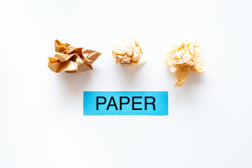 Waste suitable for recycle. Crumpled paper near printed word paper on white background top view copy space