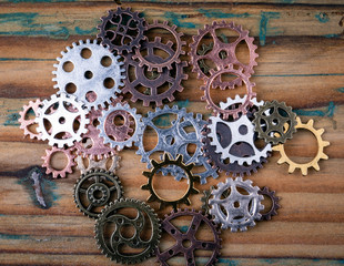 gears in different sizes and colors on wooden background. toothed wheel mechanism