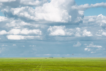 Clouds in blue skies and green grass beneath