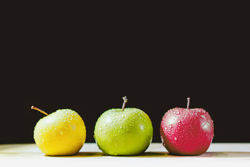 Three apples in a row with drops of water