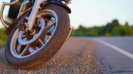 summer evening motorcycle stands by the road at sunset away from the city