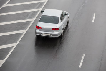 Plakat car moves on a wet multi-lane highway