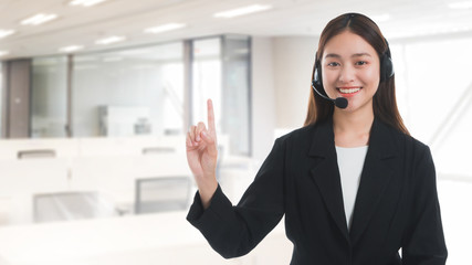Portrait of Asian beautiful smiling woman customer support phone operator on blurred business office background and copy space.Concept call center job service.