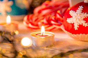 Candy Canes with Christmas decoration and lights on a wooden board