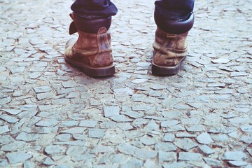 close up hipster young man legs in Jeans and leather shoes Boots outdoor back side stand on the road street city walk. Leave blank empty space to write text. concept travel.