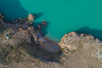 View from above, view from the air to the emerald sea with the beach and tourists by car