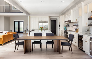 Beautiful dining room and kitchen in new luxury home with partial view of living room and entry