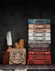 Ancient books, manuscripts and an antique inkwell on a shelf and stucco decor of gypsum plaster
