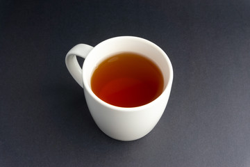 Cup of tea on dark background with selective focus and crop fragment