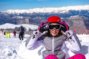 Fototapeta na wymiar happy little girl arranges ski goggles