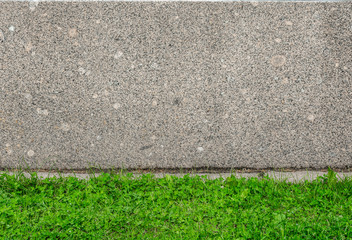 Gray granite wall and fresh green grass floor