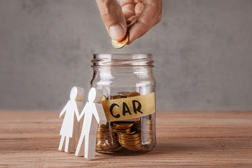 Car. Glass jar with coins and an inscription is car and symbol of  family or couple. Man holds coin
