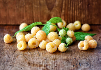 Ripe yellow raspberries on the old wooden background