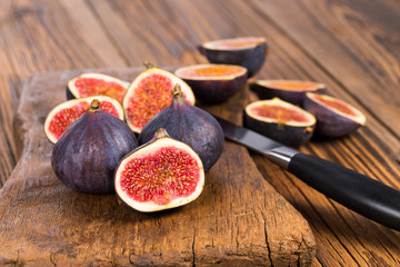 Group of whole and sliced ripe, delicious and sweets figs with a kitchen knife on a old rustic...