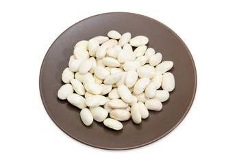 Raw white kidney beans on brown dish on white background
