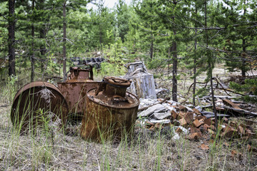 Old metal barrels in the forest and broken bricks in the forest.