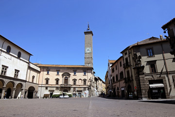 Fototapeta na wymiar Palazzo Podestà with clock tower at Plebiscito square in Viterbo, Italy