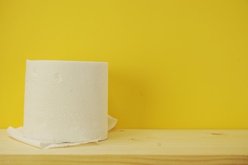 roll of toilet paper on yellow background