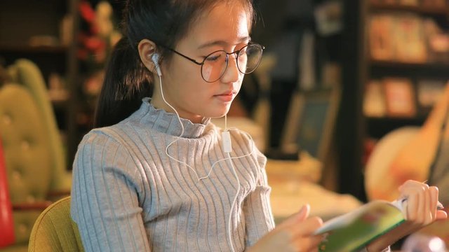 asian teenager reading booking in home living room